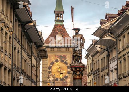 Schweiz, Kanton Bern, Bern, Schutzenbrunnen-Brunnen mit Uhrenturm im Hintergrund Stockfoto