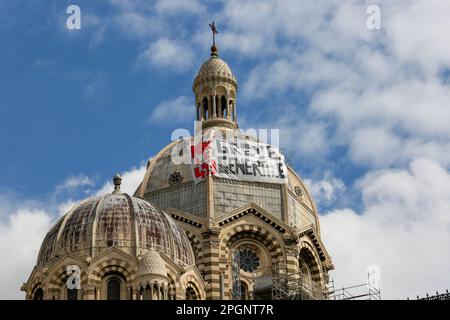 Ein Banner, das einen Generalstreik fordert, hängt an der Kathedrale von Marseille am Rande der Demonstration gegen die Rentenreform. Die französischen Gewerkschaften haben eine 9.-tägige Aktion gegen die Rentenreform der französischen Regierung gefordert, mit der das Rentenalter von 62 auf 64 Jahre angehoben werden soll. Der französische Präsident Emmanuel Macron erzwang die Rentenreform mit Artikel 49,3 der französischen Verfassung. Artikel 49,3 erlaubt es der Regierung, die Verabschiedung eines Gesetzentwurfs ohne Zustimmung des parlaments zu erzwingen Stockfoto