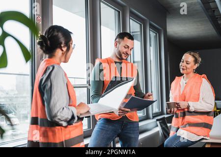 Mann trägt reflektierende Kleidung, wenn er sich mit Kollegen im Büro trifft Stockfoto