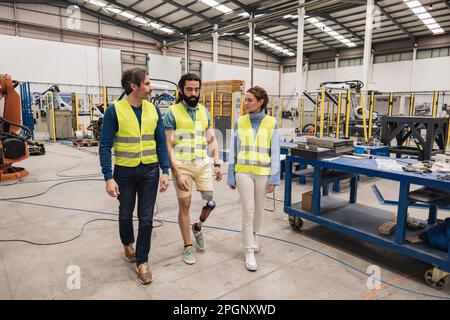 Ingenieure, die reflektierende Kleidung tragen, gehen in die Fabrik Stockfoto