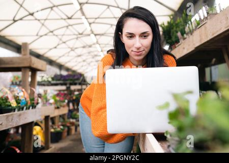 Frau, die im Gartencenter an einem Laptop arbeitet Stockfoto