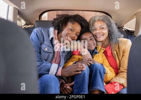 Eine Familie, die mehrere Generationen lang lächelt und im Auto sitzt Stockfoto