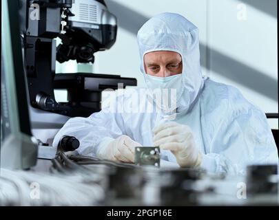 Fokussierter Wissenschaftler, der in Reinräumen arbeitet Stockfoto