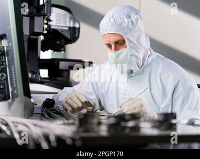 Techniker trägt Schutzanzug bei der Arbeit im Labor Stockfoto