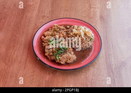 Chijaukay-Hühnchen wird aus entbeinten Hähnchenschenkeln, Mensi-Sauce und chuño-Mehl hergestellt. Vor dem Servieren wird das Fleisch in Stücke geschnitten und mit einem h besprüht Stockfoto