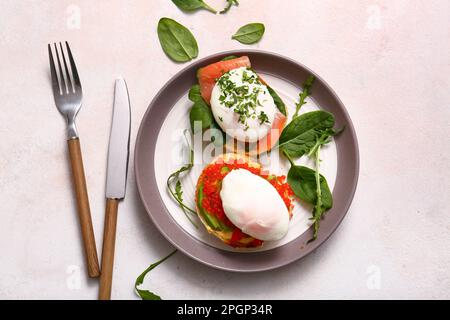 Teller mit leckeren Eiern Benedict auf weißem Tisch Stockfoto