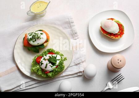 Teller mit leckeren Eiern Benedict auf weißem Tisch Stockfoto