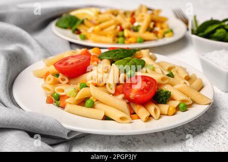 Teller mit leckerem Nudelsalat auf hellem Hintergrund, Nahaufnahme Stockfoto