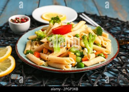 Teller mit leckeren Nudelsalat auf dem Tisch Stockfoto