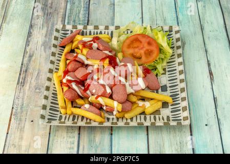 Salchipapa ist ein Fast Food, das aus gebratenen Wurstscheiben und Pommes frites besteht und in Lateinamerika beliebt ist Stockfoto