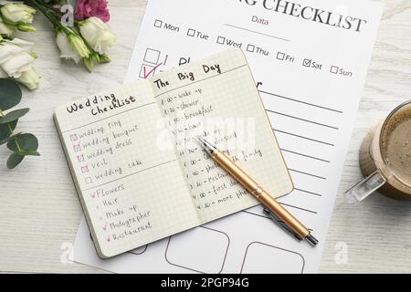 Flache Liegezusammensetzung mit Hochzeitsplaner auf weißem Holztisch Stockfoto