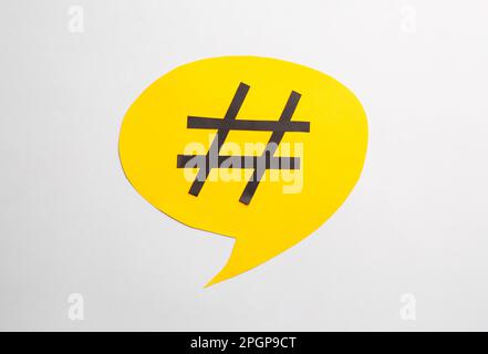 Gelbe Sprechblase mit Hashtag-Symbol auf weißem Hintergrund, Draufsicht Stockfoto