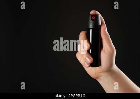 Ein Mann mit Pfefferspray auf schwarzem Hintergrund, Nahaufnahme. Platz für Text Stockfoto