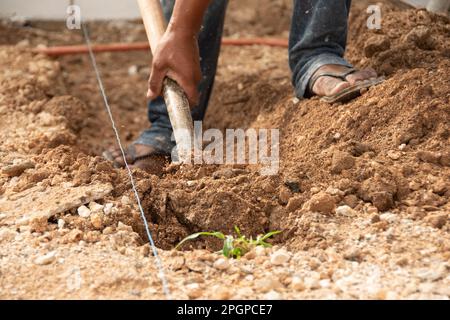 Nahaufnahme der Hand eines Mannes, der mit einer Schaufel im Boden gräbt Stockfoto