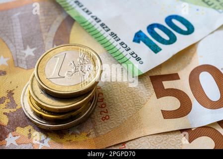 Ein Haufen Euro-Münzen befindet sich direkt neben den Euro-Banknoten. Währung der Europäischen Union. Stockfoto