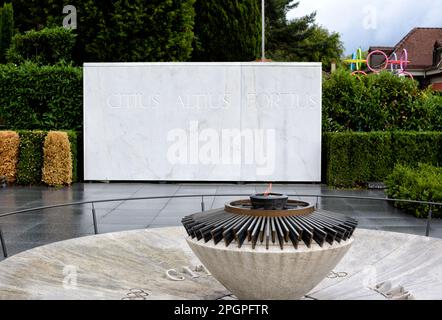 LAUSANNE, SCHWEIZ - 5. JULI 2014: Fackel im Olympischen Museum, mit Schildern schneller, höher, stärker. Stockfoto