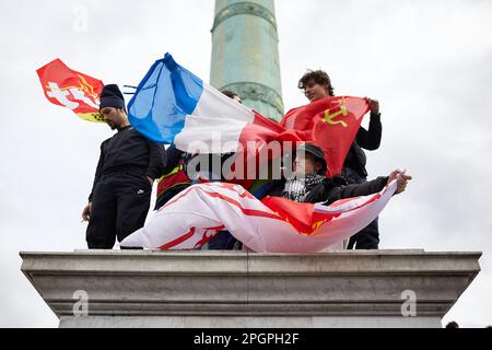 Paris, Frankreich. 23. März 2023. Eine Gruppe junger Menschen hält während der Demonstration mehrere Flaggen vor dem Denkmal auf dem Place de la Bastille. Der Generalstreik in Paris endet mit gewalttätigen Ausschreitungen zwischen Demonstranten und Polizei. Der Streik nach der Verabschiedung des neuen Rentengesetzes hat seit seiner einseitigen Genehmigung durch die Regierung von Emmanuel Macron zu täglichen Unruhen geführt. Kredit: SOPA Images Limited/Alamy Live News Stockfoto