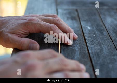 Die Hände auf dem Tisch warten darauf, dass man sich um sie kümmert Stockfoto