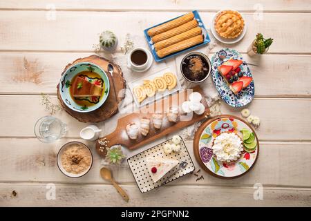 Verschiedene peruanische Gebäckstücke Desserts Buffet Tisch Brunch süße Speisen auf einem weißen Holztisch Stockfoto