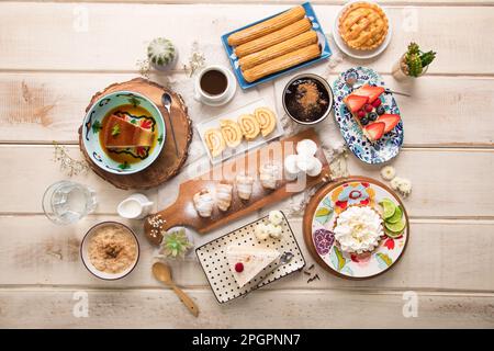 Verschiedene peruanische Gebäckstücke Desserts Buffet Tisch Brunch süße Speisen auf einem weißen Holztisch Stockfoto