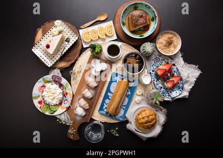 Verschiedene peruanische Desserts, Buffet, Brunch, süße Speisen auf schwarzem Hintergrund Stockfoto