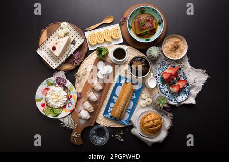 Verschiedene peruanische Desserts, Buffet, Brunch, süße Speisen auf schwarzem Hintergrund Stockfoto