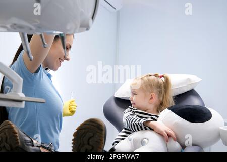 Teil eines Kieferorthopäden, der Kinderzähne in der Zahnarztpraxis untersucht. Hochwertiges Foto Stockfoto