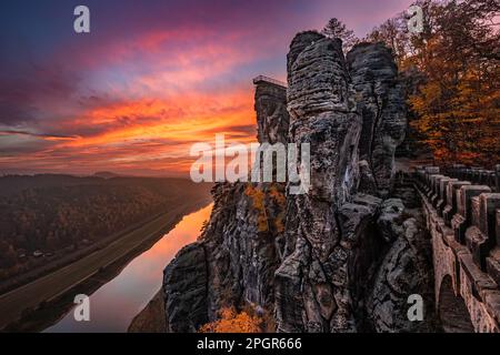 Sachsen, Deutschland - wunderschöne Felsformation der Bastei-Brücke mit spektakulärem farbenfrohen Herbstuntergang über der Elbe an einem Novembernachmittag in Sax Stockfoto