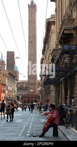 Straßenkünstler, der Cello im historischen Stadtteil Bologna spielt. Straßenkonzept. Stockfoto