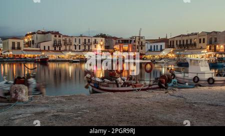 Hafengegend Rethymnon, Kreta, Griechenland, mit Lichtern, die angehen, wenn das Licht schwächer wird. Stockfoto