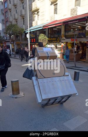 Mitarbeiter von Paketzustellungen, die große Pakete mit Handwagen auf den Straßen von Istanbul, Türkei, am 2022. Dezember liefern Stockfoto