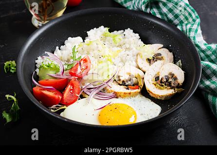 Spiegelei, Hähnchenbrötchen, Reis und Tomaten. Paleo Frühstück. Stockfoto