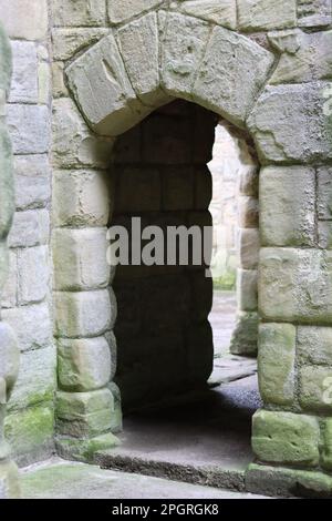 Alte Burg Bogengang umgeben von riesigen Blöcken aus alten Steinen Stockfoto