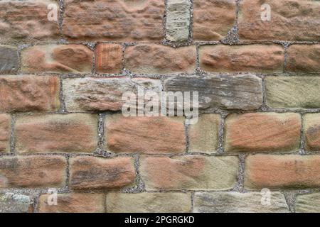 Nahaufnahme einer alten roten Ziegelmauer aus riesigen Steinblöcken Stockfoto