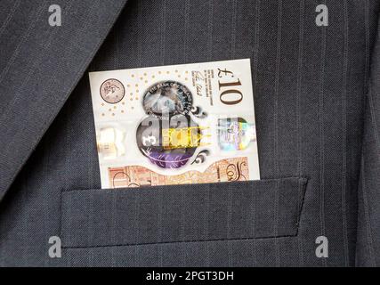 10-Pfund-Schein der Bank of England, der aus der Anzugtasche ragt Stockfoto