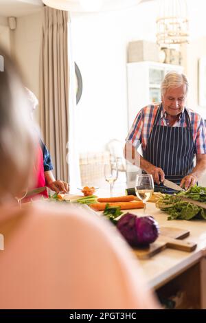 Glückliche Gruppe von verschiedenen älteren Freunden, die Schürzen in der Küche für einen Kochkurs tragen, Kopierraum. Ruhestand, Lernen, Kochen und gesunder Lebensstil. Stockfoto