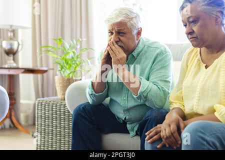 Traurige Gruppe verschiedener Senior-Freunde, die im Wohnzimmer sitzen und während der Gruppentherapie zuhören. Seniorenleben, Freundschaft und Unterstützung. Stockfoto