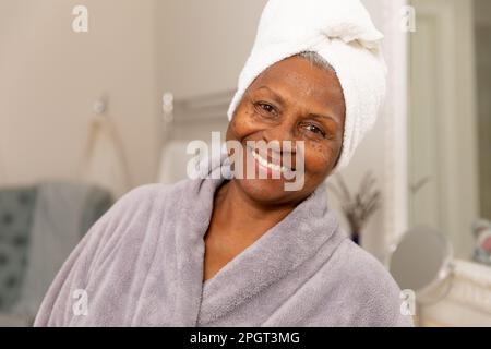 Nahaufnahmen von einer lächelnden, frischen afroamerikanischen Seniorin, die zu Hause in Bademänteln steht. Unverfälscht, Körperpflege, Altern, Verwöhnung, Lebensstil Stockfoto