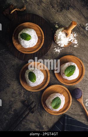 Japanischer Mochi oder Reiskuchen gefüllt mit roten Bohnen und Erdbeeren, Minzblätter oben drauf. Traditioneller japanischer Reiskuchen. Stockfoto