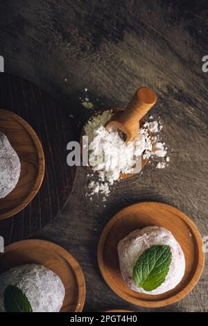 Japanischer Mochi oder Reiskuchen gefüllt mit roten Bohnen und Erdbeeren, Minzblätter oben drauf. Traditioneller japanischer Reiskuchen. Stockfoto