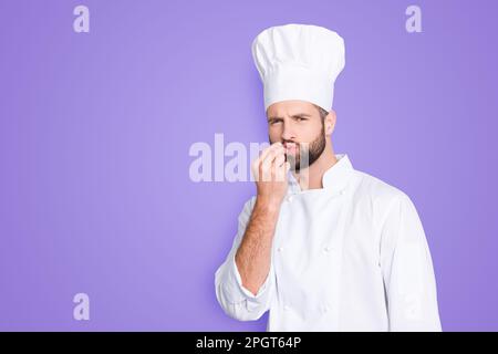 Porträt mit Kopierraum, leerer Platz für Werbung Produkt des gutaussehenden Kochs in Baskenmütze, weißes Outfit, das Bellisimo-Symbol macht, Schild mit Schmollmund Stockfoto