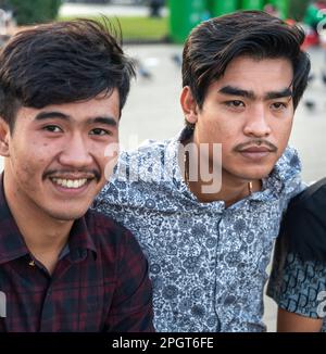 Phnom Penh, Kambodscha-Dezember 23. 2022: Männliche kambodschanische Teenager treffen sich mit anderen Teenagern und Familie, in der relativ kühlen Atmosphäre des frühen Abends, um sich zu treffen Stockfoto