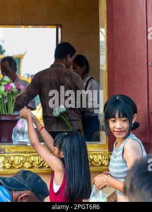 Phnom Penh, Kambodscha-Dezember 23. 2022: Spenden von Nahrung und Blumen im heiligen Schrein, buddhistische Anhänger stellen sich bei einer Witwe an, um die Sache weiterzugeben Stockfoto