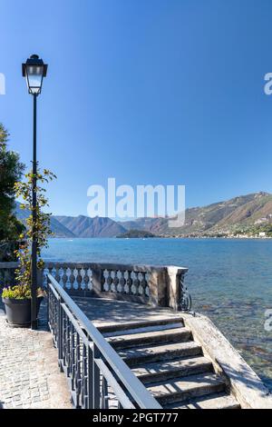 Zierbalustrade und Lampenpfahl, die zur Bootsanlegestelle am Ufer des comer Sees am sonnigen Tag in bellagio führen Stockfoto