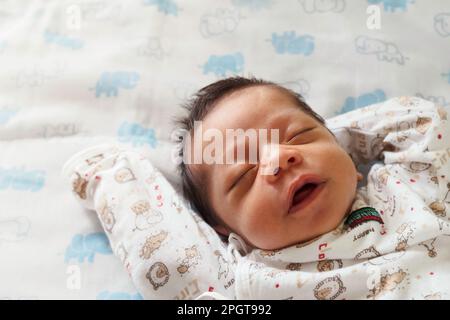 Fröhlicher süßer asia-Neugeborener, der morgens im Kinderzimmer mit Kopierbereich schläft. Familie und Gesundheitskonzept Stockfoto