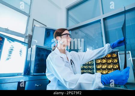 Medizinische Radiologin-Ärztin schaut Kopf- und Hirnröntgenfilm vor der Operation in der Laborpraxis des Krankenhauses. Gesundheitswesen und Bildung. Stockfoto