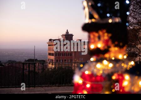 Die Weihnachtsdekoration glänzt vor dem alten römischen Haus und bietet einen weiten Blick auf Rom. Stockfoto