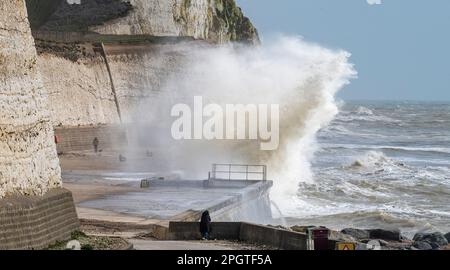 Brighton UK 24. März 2023 - Wanderer beobachten riesige Wellen, die über den undercliff Walk in Saltdean östlich von Brighton stürzen, mit starken Winden vermischt mit der Sonnenvorhersage für die Südküste heute : Credit Simon Dack / Alamy Live News Stockfoto