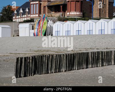 Strandhütten mit kleinen Booten und einem Wellenbrecher aus Holzpfählen der Stadt im Le Crotoy, einer Kommune im Somme Department Stockfoto