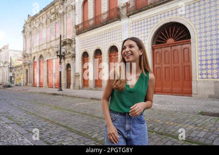 Lächelndes, stilvolles Mädchen, das das historische Zentrum von Santos, Sao Paulo, Brasilien, besucht Stockfoto